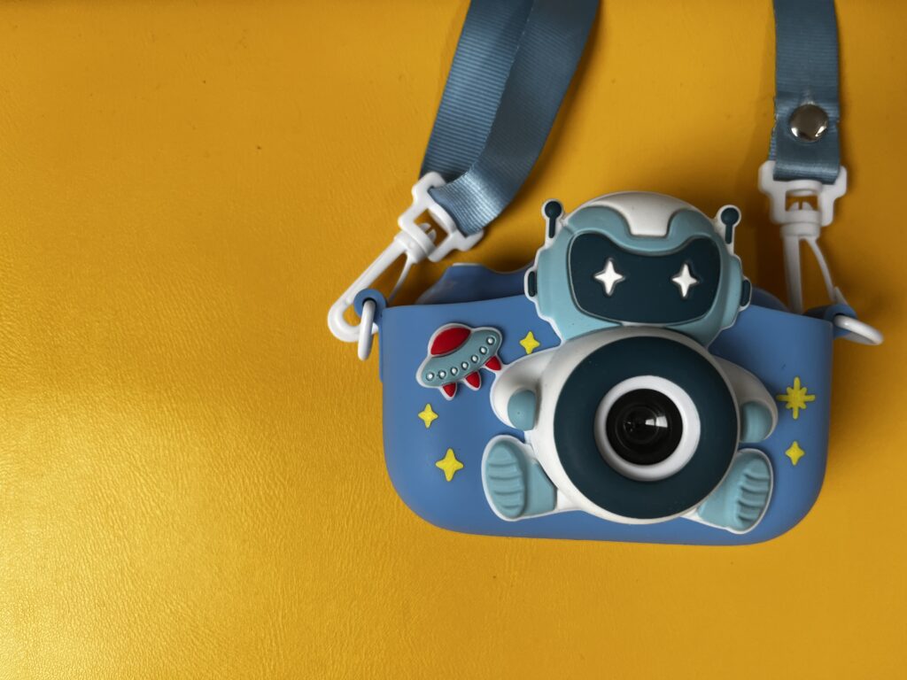 Blaue Kinderkamera auf gelben Hintergrund